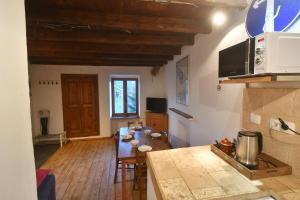 a living room with a table and a kitchen at petite maison à Huez in LʼHuez