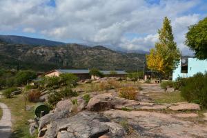 Cabañas El Refugio de Juan في مينا كلافيرو: منزل في حقل مع جبال في الخلفية