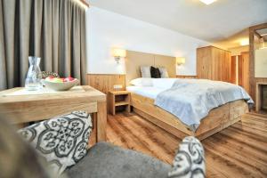 a hotel room with a bed and a bowl of fruit at Hotel Maria Theresia in Ischgl