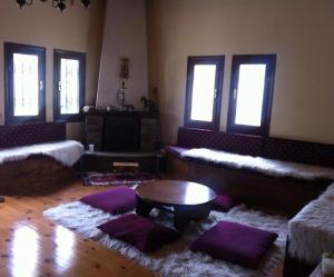 a living room with purple pillows and a table at “White Mountain”, Pisoderi in Pisoderi