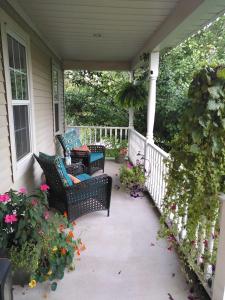 a porch with chairs and flowers on a house at Old Town Country Landing in Niagara on the Lake