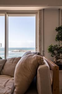a person laying on a couch in front of a window at Sandhi House - Yoga & Wellness in Ericeira