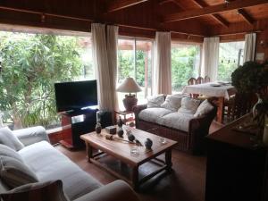 uma sala de estar com sofás e uma mesa de centro em Cabaña San Vicente em llifen
