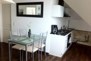 a kitchen with a table and chairs and a sink at Appartement front mer proche omaha & utah beach - 3 in Grandcamp-Maisy