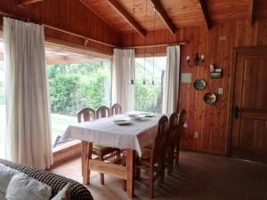 a dining room with a table and chairs and a window at Cabaña San Vicente in llifen