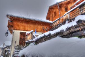 uma casa com neve nas escadas em frente em petite maison à Huez em LʼHuez
