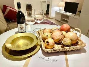 a table with a basket of apples and a bottle of wine at Casa di Vasco - Home of Vasco in San Miniato