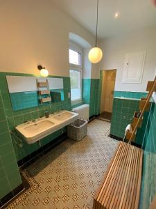 uma casa de banho verde com uma banheira e um lavatório em Fabelhaus em Traben-Trarbach