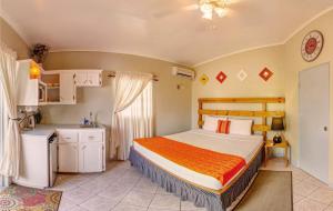 a bedroom with a large bed and a kitchen at Papaya Inn in Oranjestad