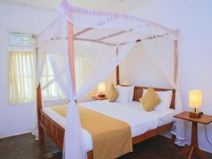 a bedroom with a bed with a canopy at Thalpe Walawwa Heritage Villa With Private Beach Access in Unawatuna +111 photos