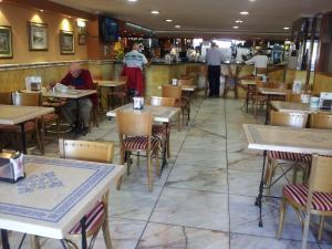 a restaurant with tables and chairs and people sitting at them at Begoña Playa in Gijón