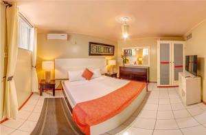 a bedroom with a large bed and a desk at Papaya Inn in Oranjestad