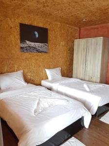two twin beds in a room with a wall at Bottle Beach 2 Bungalows in Bottle Beach