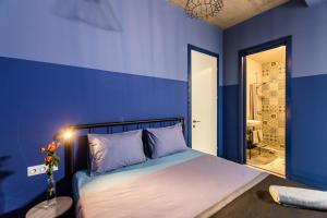 第比利斯Modern Avlabari in Old Town的蓝色的卧室,配有一张蓝色墙壁的床