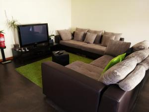 a living room with a couch and a flat screen tv at Barranha Beach House in Aguçadoura
