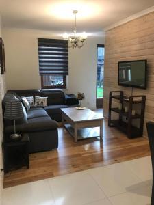 a living room with a black couch and a tv at Apartament Centrum Zakopane in Zakopane