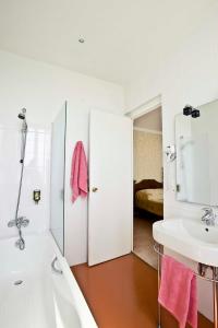 ein Badezimmer mit Badewanne und Waschbecken und ein Bett in der Unterkunft Hotel Les Goelands in Saint-Jean-de-Luz