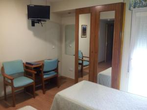 a room with a bed and a table and chairs at Begoña Playa in Gijón