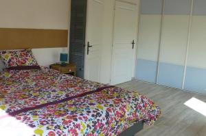 una camera da letto con un copriletto colorato di Le fief Beaurepaire 76280 a Beaurepaire