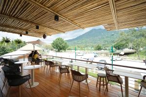 a restaurant with tables and chairs and a view of a river at Passion Resort Kiriwong in Khiriwong