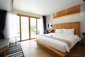 a bedroom with a large bed and a large window at Passion Resort Kiriwong in Khiriwong +62 photos