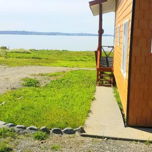 un porche de una casa con vistas al océano en Cabañas Tripanko Chiloe, en Ancud