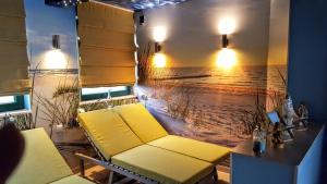 Habitación con sofá y pintura de playa en Avila Park & SPA, en Dziwnówek