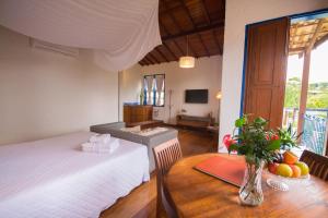 a room with a table and a bed and a table sidx sidx sidx at Pousada Vivenda in Tiradentes