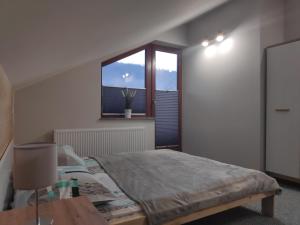 Schlafzimmer mit einem Bett mit einem Tisch und einem Fenster in der Unterkunft Domek nad Żylicą in Szczyrk