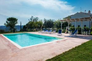 a swimming pool with blue chairs and a house at Villa Marchetti in Cupra Marittima