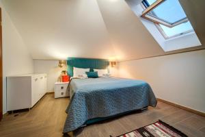 um quarto com uma cama com uma colcha azul e uma janela em Zlatibor Hills Stars em Zlatibor
