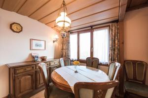 a dining room with a table and chairs and a window at Chalet Fernblick in Beatenberg