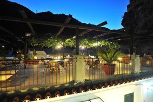 un patio al aire libre con mesas y sillas por la noche en Villa Adriana Amalfi, en Amalfi