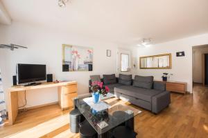 a living room with a couch and a tv at Holiday Apartment Alpenblick in Brienz