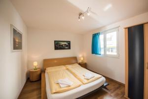 a bedroom with a bed with two pillows on it at Alpenblick - Direct lake view in Brienz +23 photos