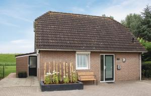 una casa de ladrillo con un banco delante de ella en Vakantiewoning aan het Veerse meer, en Wolphaartsdijk