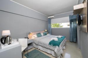 a small bedroom with a bed and a window at Urbano Hotel in Montevideo