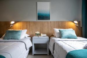 a hotel room with two beds and two lamps at Urbano Hotel in Montevideo
