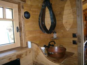 baño con pared de madera y lavabo de cobre en Chambre d'hôte atypique "trappeur" West little ranch, en Guiscriff