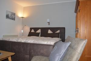 a bedroom with a large bed and a couch at Hoffmann's Apartment in der Residenz Bocksbergblick in Hahnenklee-Bockswiese