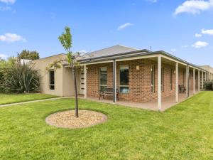 a house with a palm tree in the yard at THE LOCH SURFSIDE WIFI - NETFLIX - PET FRIENDLY (OUTSIDE ONLY) in Inverloch