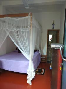 een slaapkamer met een hemelbed bij Sun Ocean Inn Mirissa in Mirissa