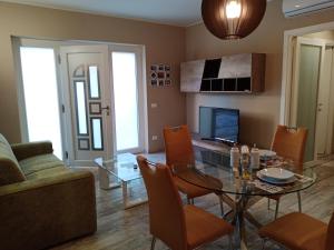 a living room with a glass table and a couch at Appartamento "Il Vicolo" in Peschiera del Garda