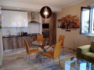 cocina y comedor con mesa y sillas en Appartamento "Il Vicolo" en Peschiera del Garda