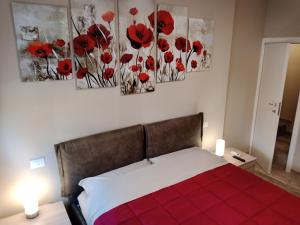a bedroom with red poppies paintings on the wall at Appartamento "Il Vicolo" in Peschiera del Garda