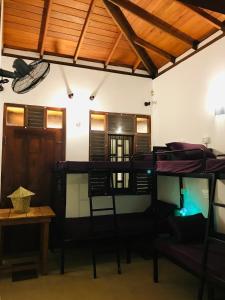 a room with several bunk beds and a table at J Walker Hostel in Weligama