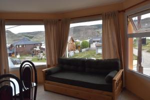 a couch in a room with a large window at Lagos del Sur in El Chalten