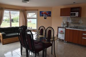 a kitchen and dining room with a glass table and chairs at Lagos del Sur in El Chalten