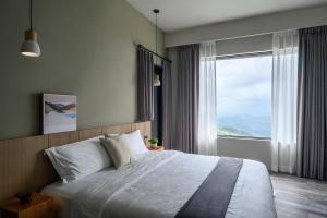 a bedroom with a large bed with a large window at Two Easy Inn in Jiufen