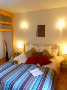 Un dormitorio con una cama con dos libros. en Les Balcons De Recoin - Chamrousse, en Chamrousse